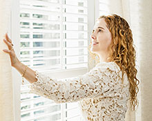 woman closing blinds